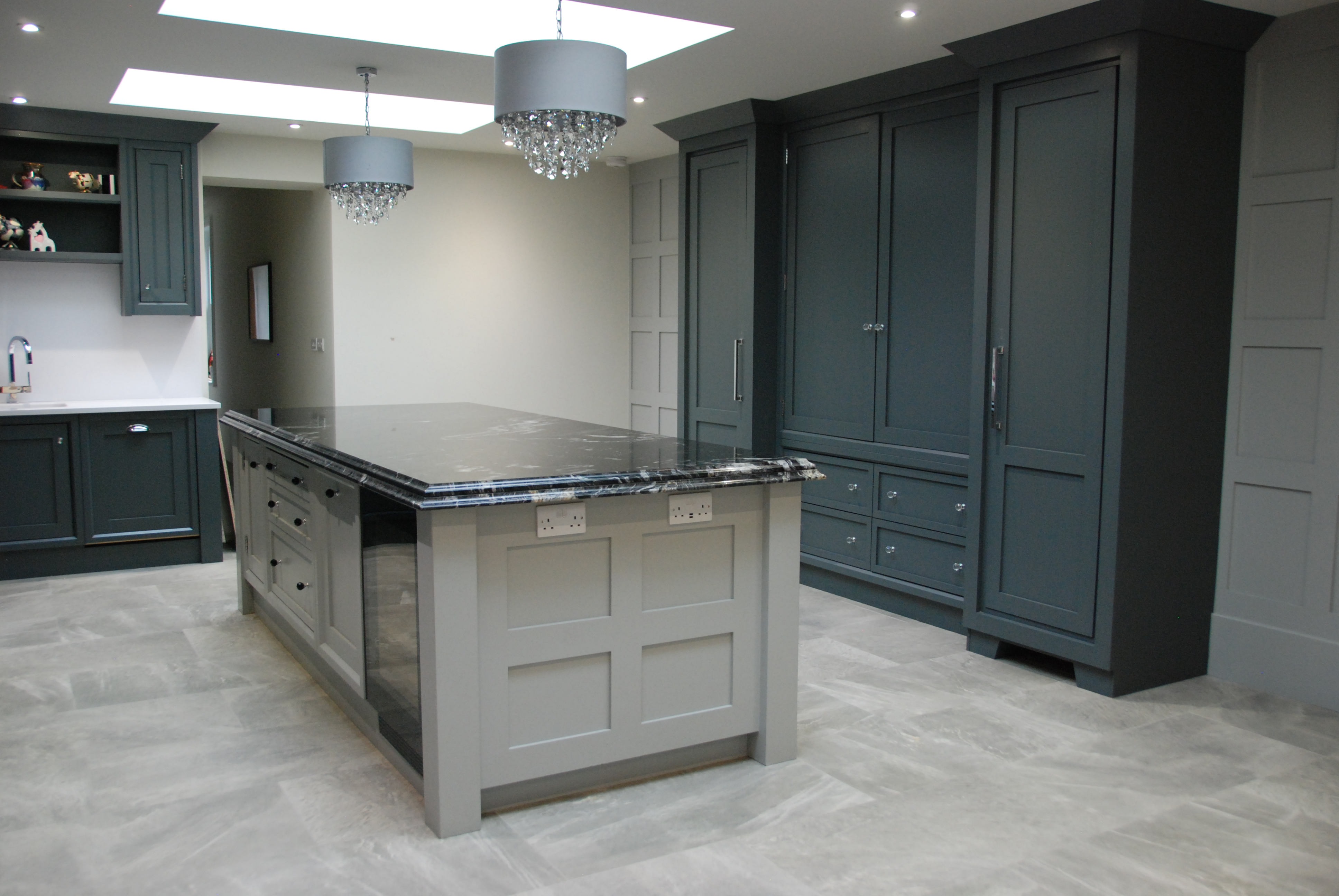 Large kitchen with dark cabinetry and marble countertop
