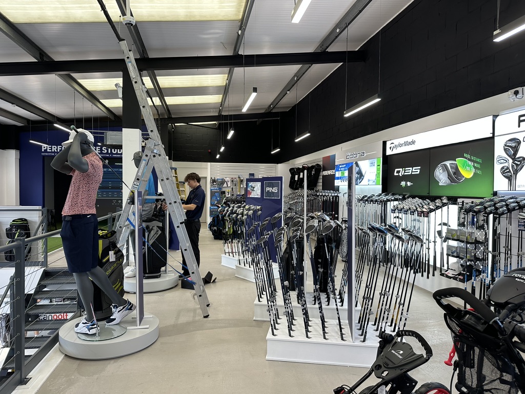 Wide store view with branded club displays and mannequins